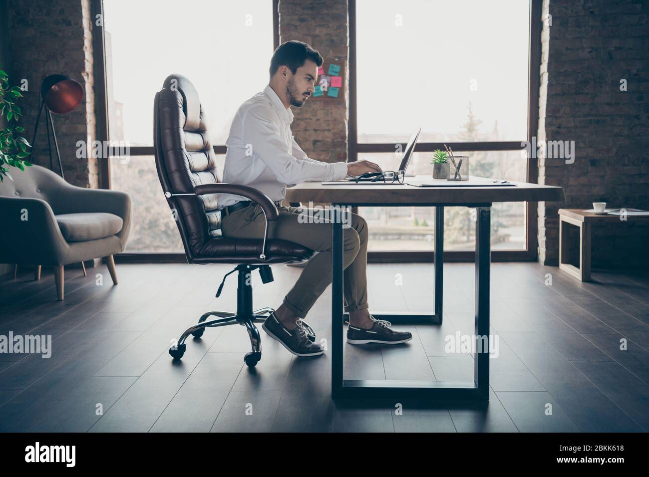 Profil Seitenansicht seiner er schön attraktiv chic zuversichtlich fokussierten Mann qualifizierte IT-Experte Ökonom sitzt im Stuhl Vorbereitung Bericht auf modernen Loft Stockfoto