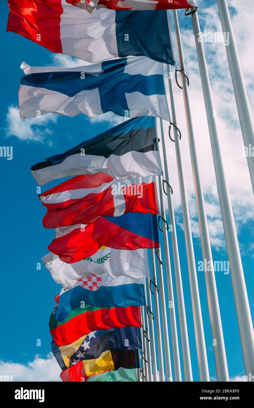 Flaggen europäischer Länder, die sich auf Fahnenmasten in der Nähe des Gebäudes entwickeln Stockfoto