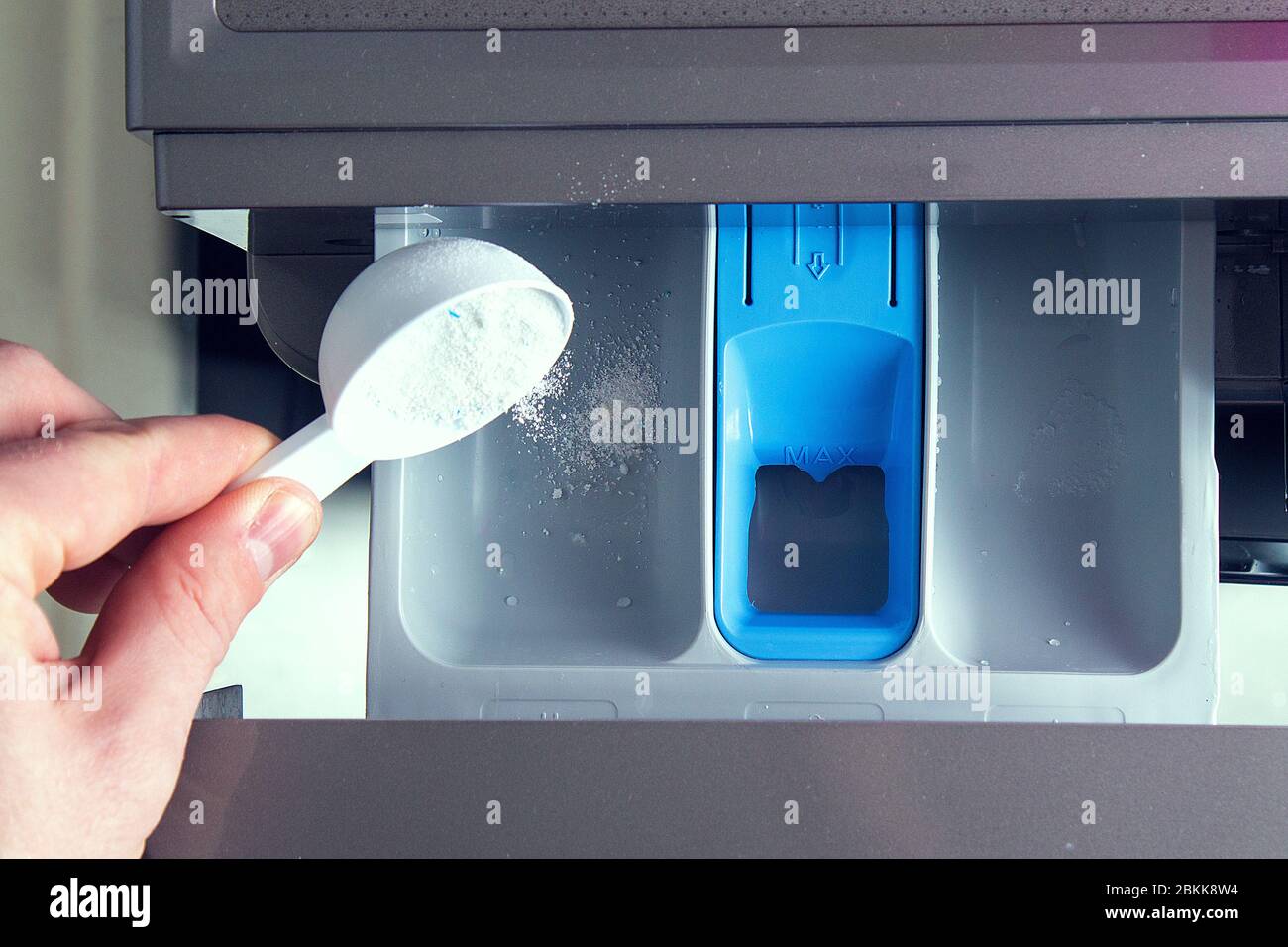Ein Mann gießt Seifenpulver, gießt Conditioner, Weichmacher in das Tablett  der Waschmaschine Stockfotografie - Alamy