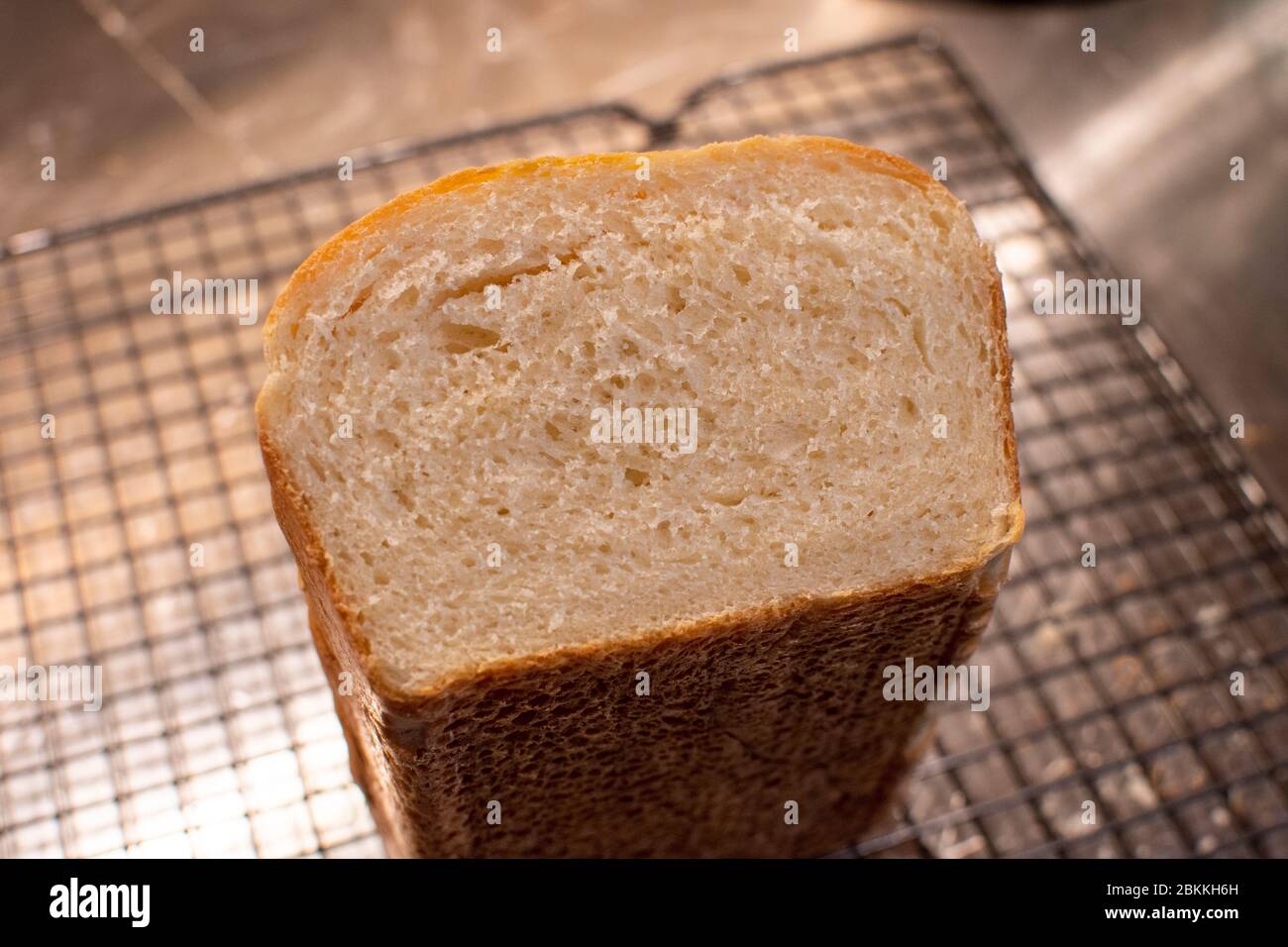 Blick auf das Ende eines frisch gebackenen Weißbrotes enthüllt die luftige Textur des Laibs Stockfoto