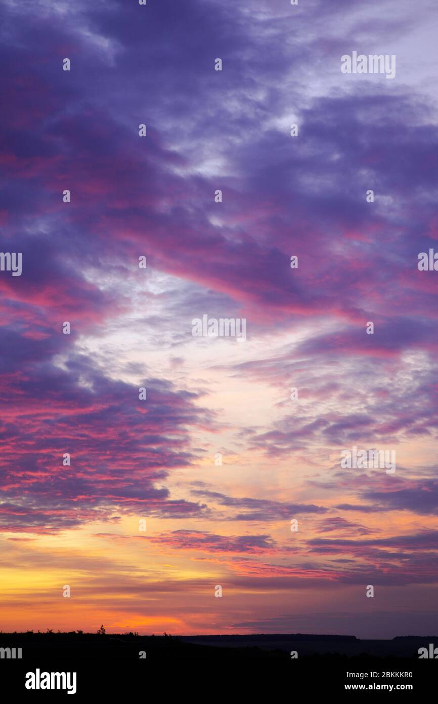 Tiefer Himmel über dem Horizont. Heller Sonnenuntergang mit Wolken Stockfoto