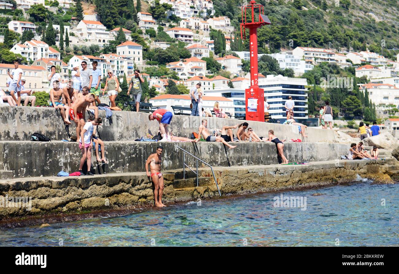 Sonnenbaden und Schwimmen an den Mauern der Altstadt von Dubrovnik, Kroatien. Stockfoto