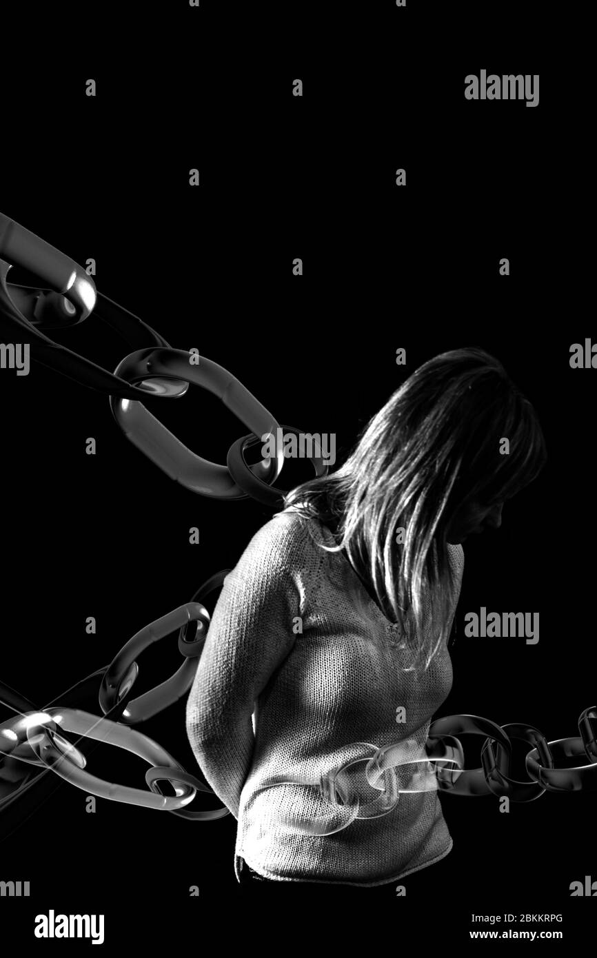 Frau in Ketten gefangen. Konzept der Gewalt gegen Frauen. Schwarz-Weiß-Studioaufnahme. Stockfoto
