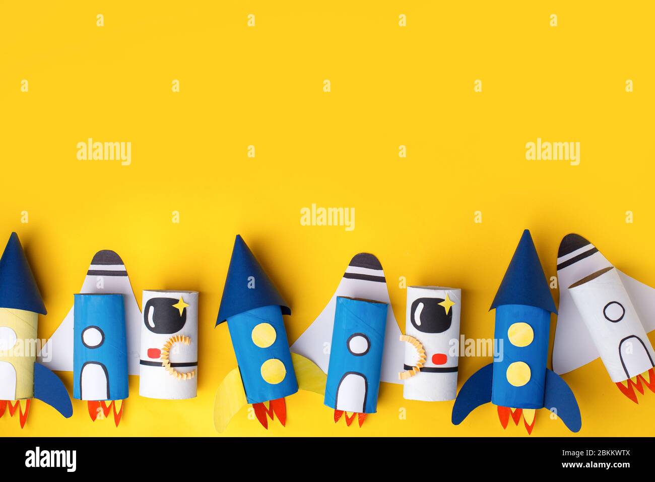 Schule Kindergarten Handwerk, Papier Raumschiff, Shuttle, Astronaut auf gelbem Hintergrund mit Kopierraum für Text. Party, Start up Launch Concept, diy, cr Stockfoto