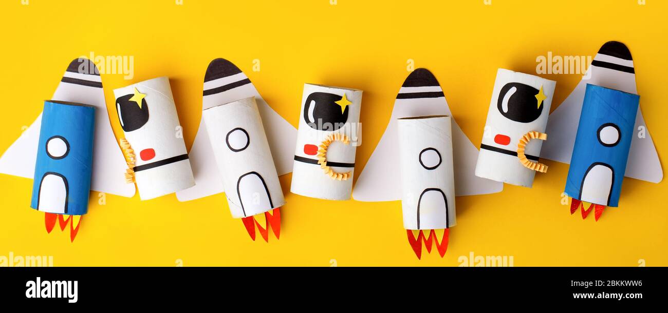 Schule Kindergarten Handwerk, Papier Raumschiff, Shuttle, Astronaut auf gelbem Hintergrund mit Kopierraum für Text. Party Konzept Handwerk, diy, kreativ Stockfoto