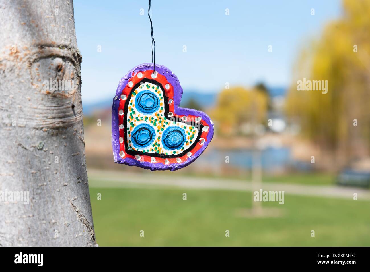 Penticton, British Columbia/Kanada - 16. April 2020: Während der COVID-19 Pandemie hängt ein handgemachtes Herz von einem Baum. Stockfoto