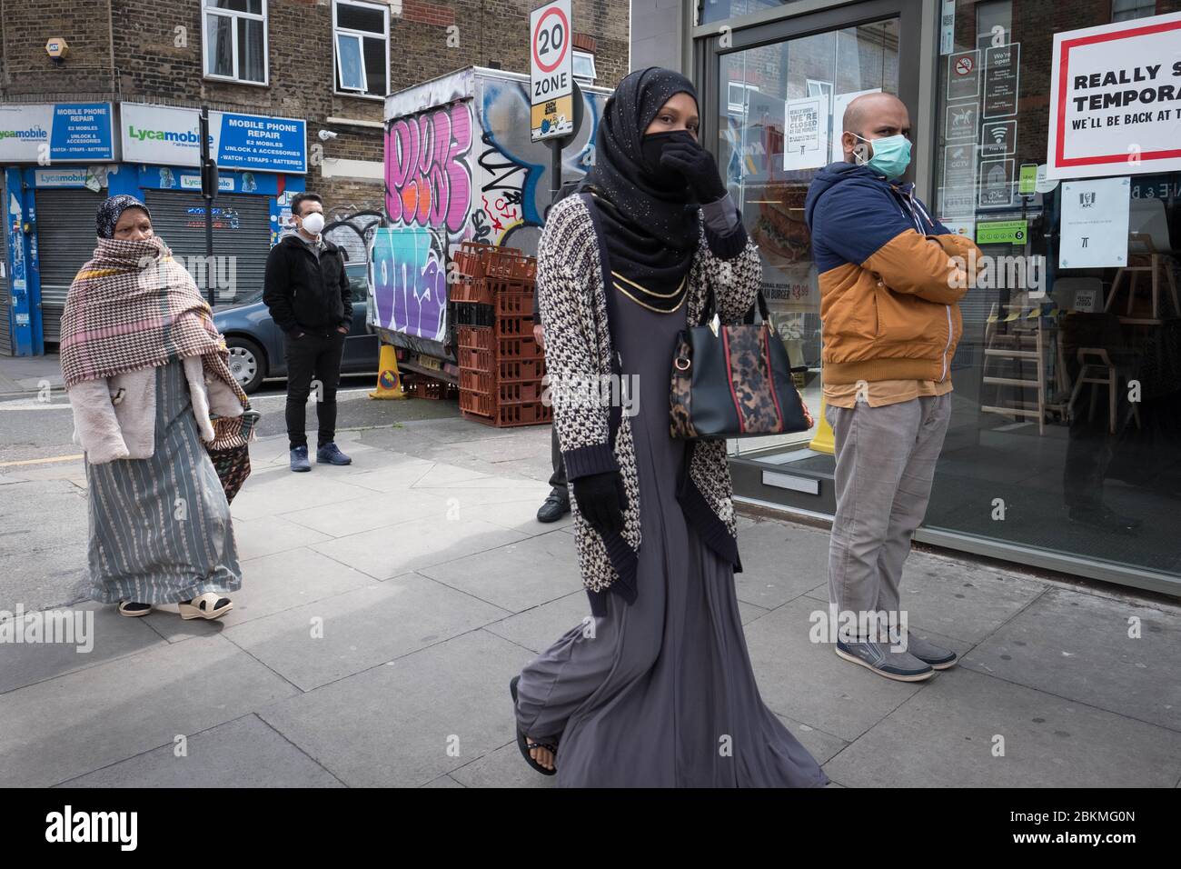 Mitglieder der islamischen Gemeinschaft in Bethnal Green, East London, gehen während des heiligen Monats Ramadan ihre täglichen Geschäfte durch, während Großbritannien weiterhin in der Lockdown-Zeit ist, um die Ausbreitung des Coronavirus einzudämmen. Stockfoto