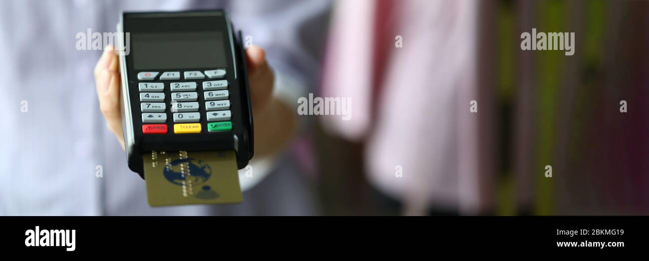 Frau hält POS-Termial mit Goldplastik-Debitkarte in der Hand Stockfoto