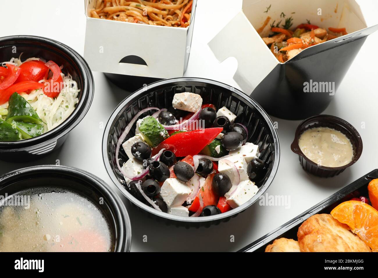 Lieferung von Lebensmitteln. Lebensmittel in Take Away-Boxen auf weißem Hintergrund Stockfoto