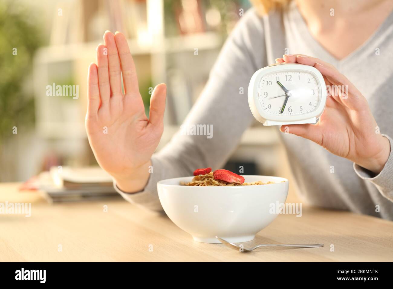 Nahaufnahme der Frau Hände auf intermittierendes Fasten tun Stop-Zeichen warten, bevor Sie essen Müslischale auf einem Tisch zu Hause Stockfoto