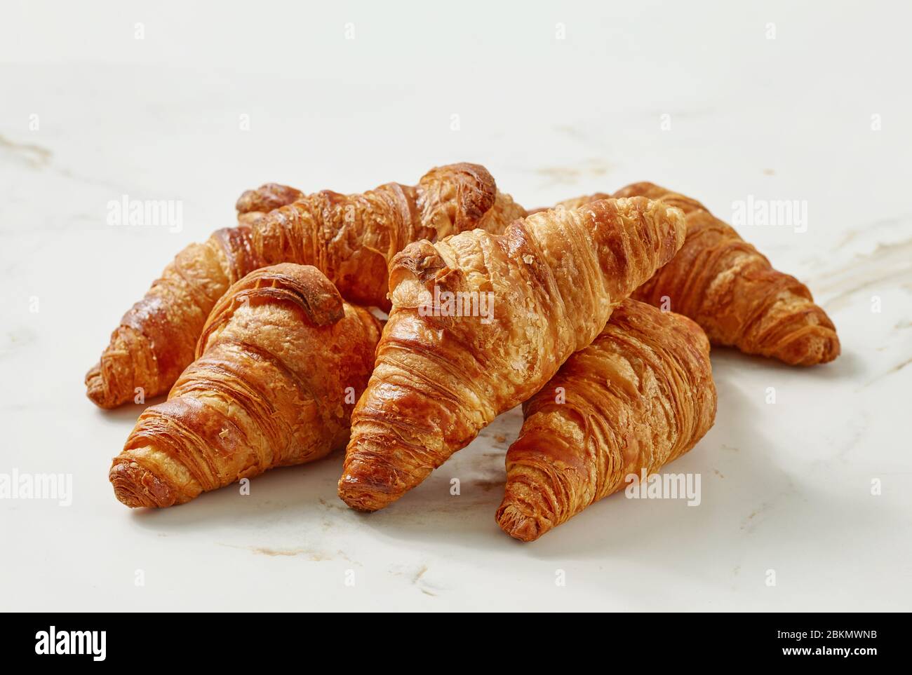 Frisch gebackene Croissants auf einem hellen Küchentisch Stockfoto