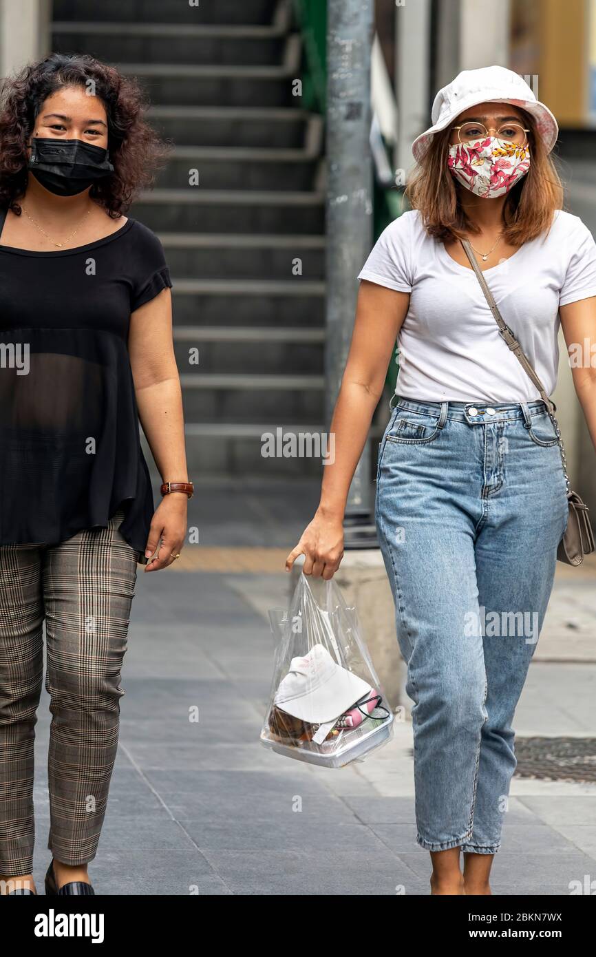 Thai-Mädchen trägt Gesichtsmaske auf Sukhumvit Road während Covid 19 Pandemie, Bangkok, Thailand Stockfoto
