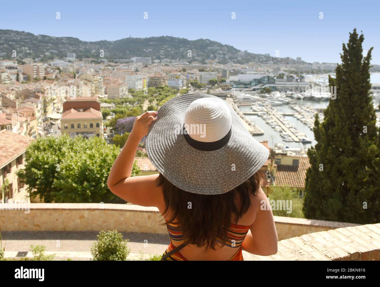 Frau in einem Hut schaut auf den Strand und die Promenade von Cannes. Stockfoto