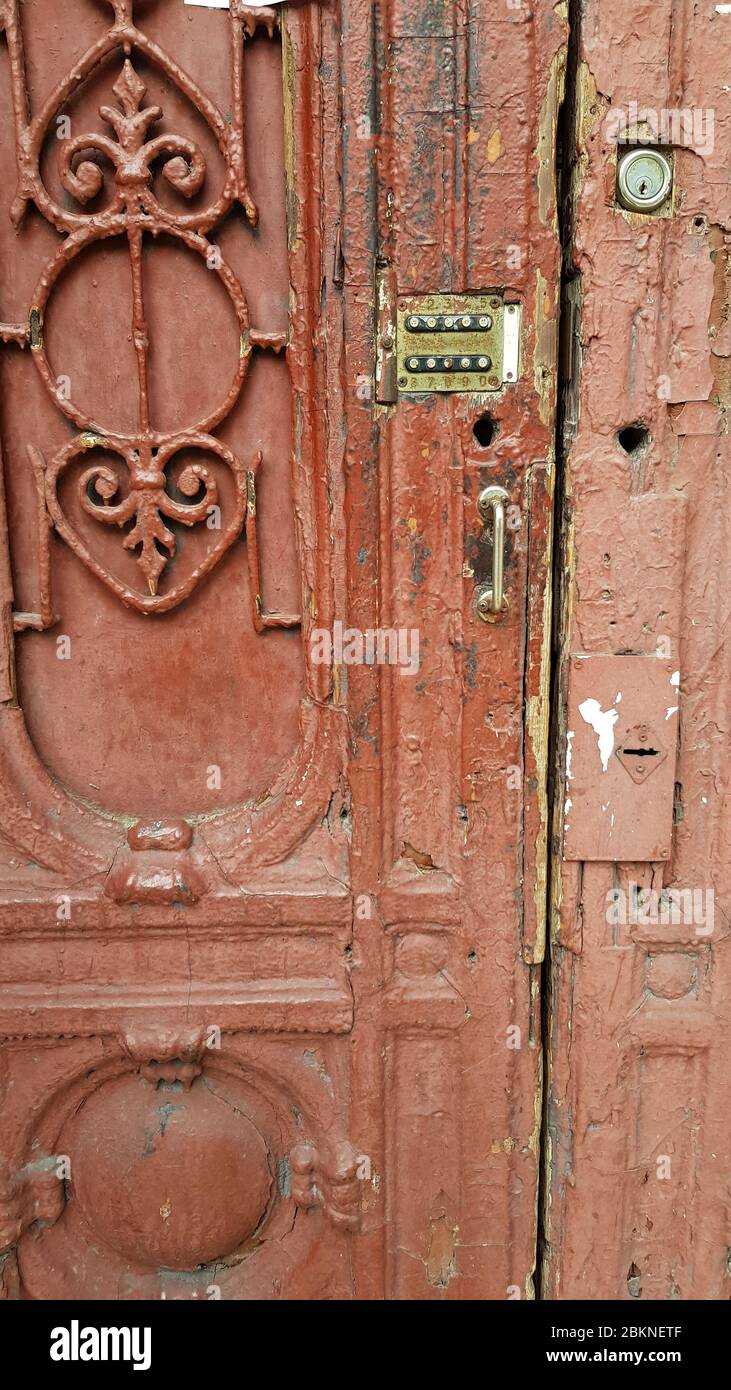 Beschädigte Oberfläche der alten Holztür mit verzierten Gitterfragment und Retro-Schloss der Gegensprechanlage Tastatur. Grunge Details des verfallenen Gebäudes en Stockfoto