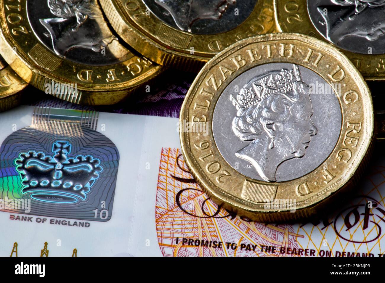 Holographische Sicherheitsfunktion auf der neuen 10 Pfund-Note und der neuen 12-seitigen ein-Pfund-Münzen Stockfoto