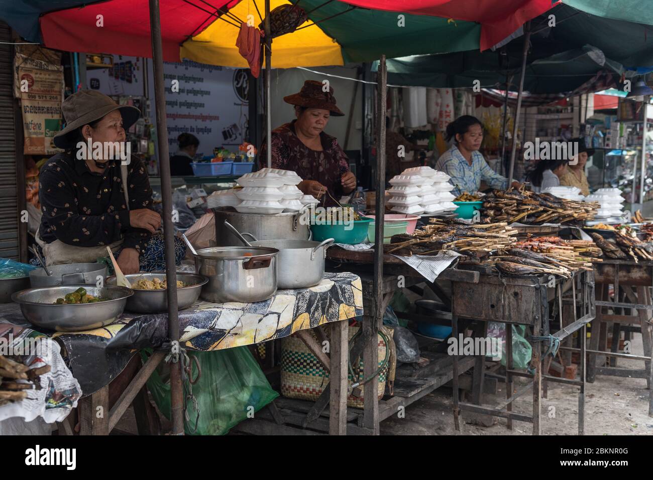 Kambodschanische Frauen verkaufen gekochten Fisch zum Mitnehmen auf dem Fischmarkt, Phnom Penh, Kambodscha Stockfoto