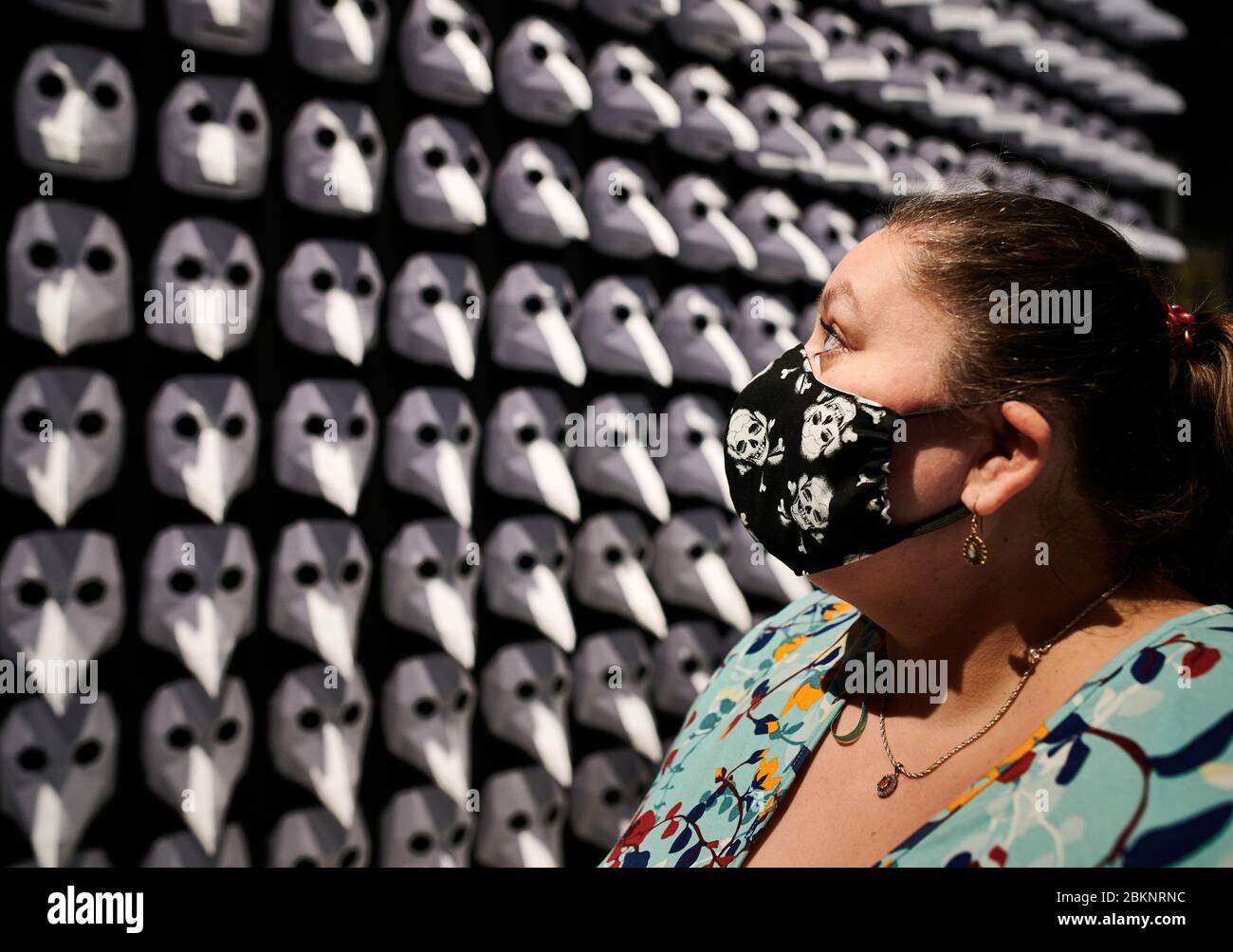 05. Mai 2020, Nordrhein-Westfalen, Herdecke: Die Besucherin Ingrid Cosic, die in der Ausstellung "Pest - SPURENSUCHE" im LWL-Archäologiemuseum eine Gesichtsmaske mit Totenkopf trägt, steht vor einer Ausstellung von 300 sogenannten Pestmasken, die im Mittelalter von Ärzten zeitweise als "Dr." getragen wurden Schnabel' zum Schutz vor Infektion mit der Pest. Die Museen des Landschaftsverbandes Westfalen-Lippe sind ab Dienstag (5.5.) wieder geöffnet. Die Sonderausstellung zur Pest wurde aufgrund der vorherigen Schließung bis zum 15. November verlängert. Foto: Bernd Thissen/dpa Stockfoto