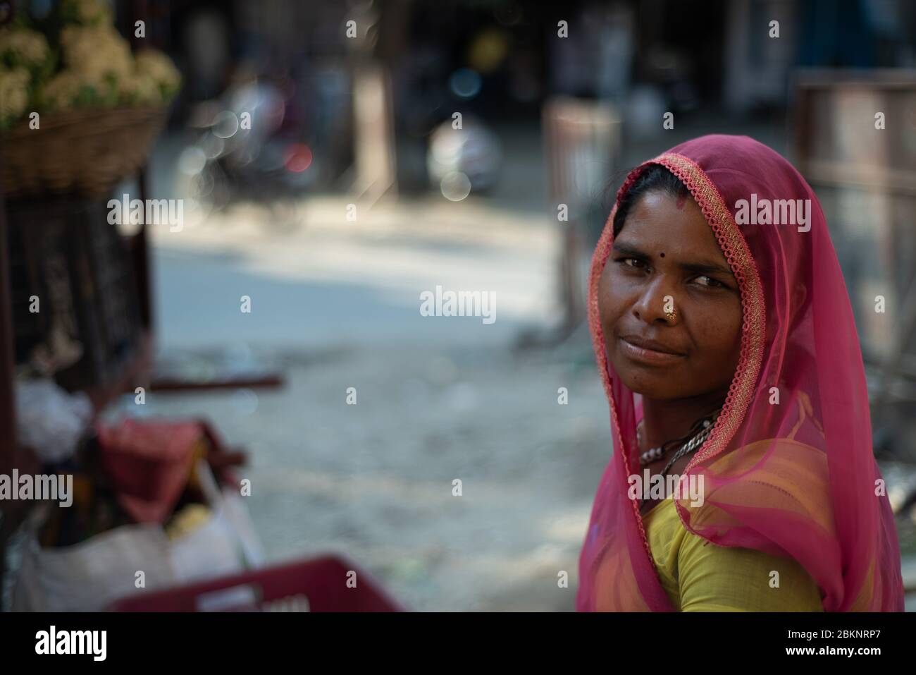 Nahaufnahme Porträt einer indischen Dame mit verschwommener Straßenszene im Hintergrund. Udaipur, Rajasthan, Indien Stockfoto