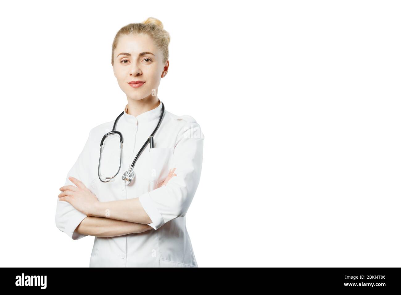 Attraktive Ärztin im medizinischen Mantel und Stethoskop mit Kopienraum auf isoliertem Hintergrund. Healthcare Medicine People Konzept Stockfoto