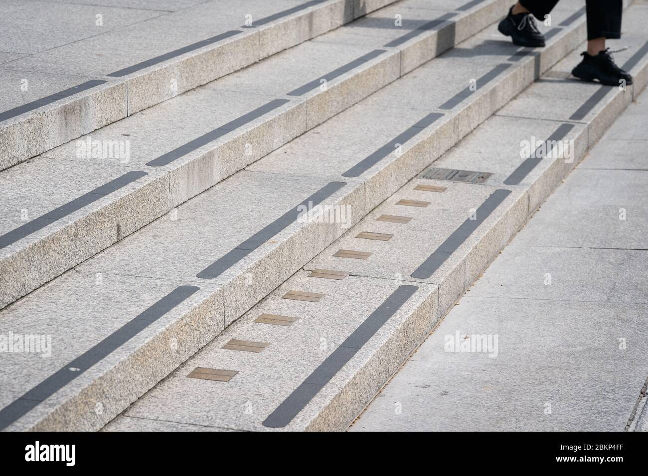Eine Person passiert die Imperial-Messmarkierungen, die auf den Stufen zur National Portrait Gallery am Trafalgar Square in London eingebettet sind, während Großbritannien weiterhin in der Sperre bleibt, um die Ausbreitung des Coronavirus einzudämmen. Stockfoto