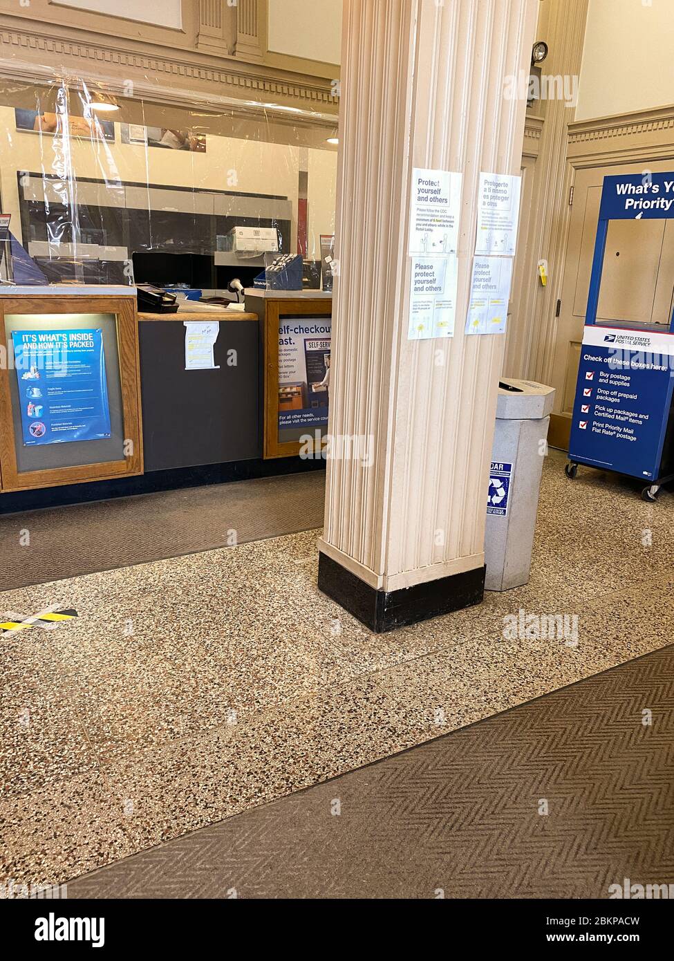 Schutzmaßnahmen im Postamt in Wilmette, IL (Vorort von Chicago). Kunststofffolien und Abstandsmarkierungen sind sichtbar. Stockfoto