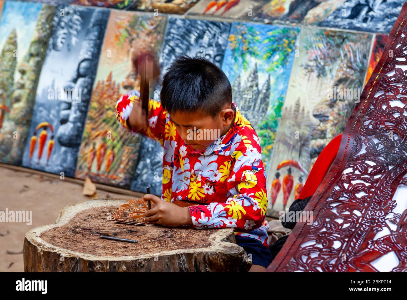 Ein lokaler Kinderkünstler, der mit Leder im Banteay Kdei Tempel, Angkor Wat Temple Complex, Siem Reap, Kambodscha arbeitet. Stockfoto