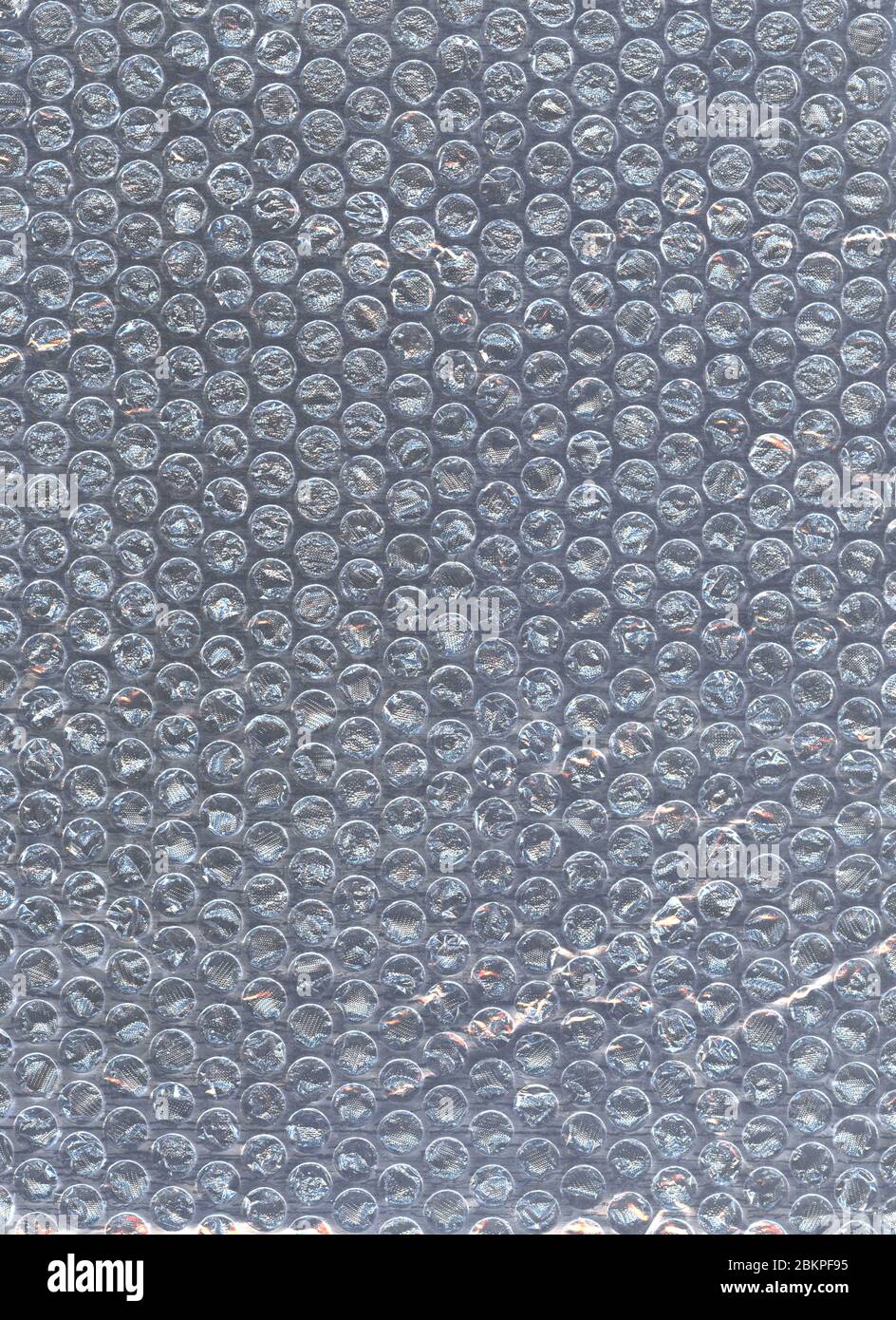 Luftblasenumschlag auf dunklem Hintergrund. Sealed Air verkauft. Knallender Luftpolsterfolie. Kunststoff Nahaufnahme Textur. Bubble Cellophan-Paket. Abstraktes Flatlay, Draufsicht Stockfoto