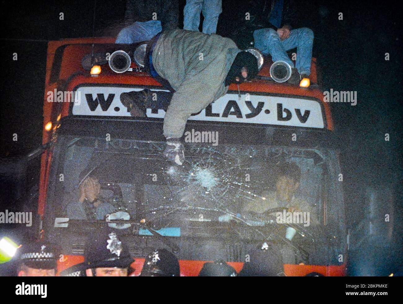 Tierschutzprotesterin mit Sturmhaube zerschlägt im Januar 1995 die Windschutzscheibe eines Lastkraftwagen, der lebende Tiere von den Shoreham Harbour Docks nach Europa transportiert Stockfoto