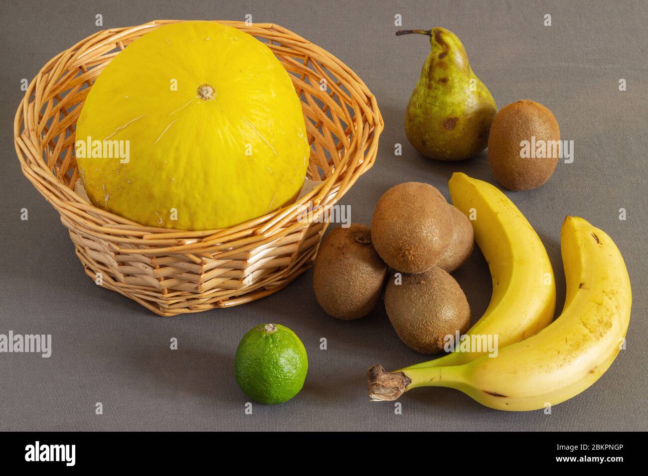Melone in einem Korb und Obst an der Seite. Obst für ein leckeres und gesundes Frühstück. Stockfoto