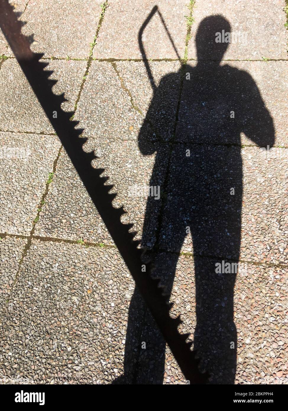 Schatten eines Mannes, der eine Säge hält, Bron, Frankreich Stockfoto