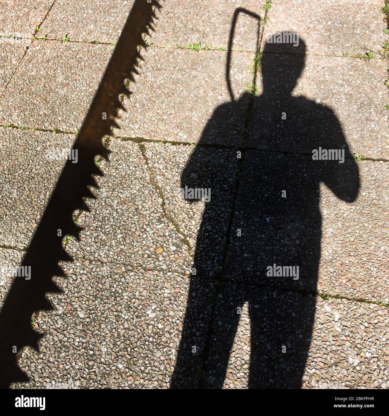 Schatten eines Mannes, der eine Säge hält, Bron, Frankreich Stockfoto