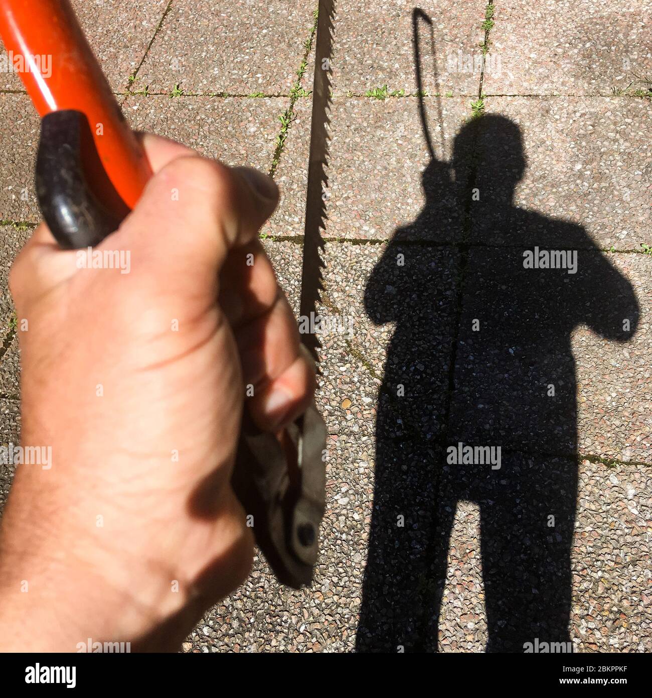 Schatten eines Mannes, der eine Säge hält, Bron, Frankreich Stockfoto