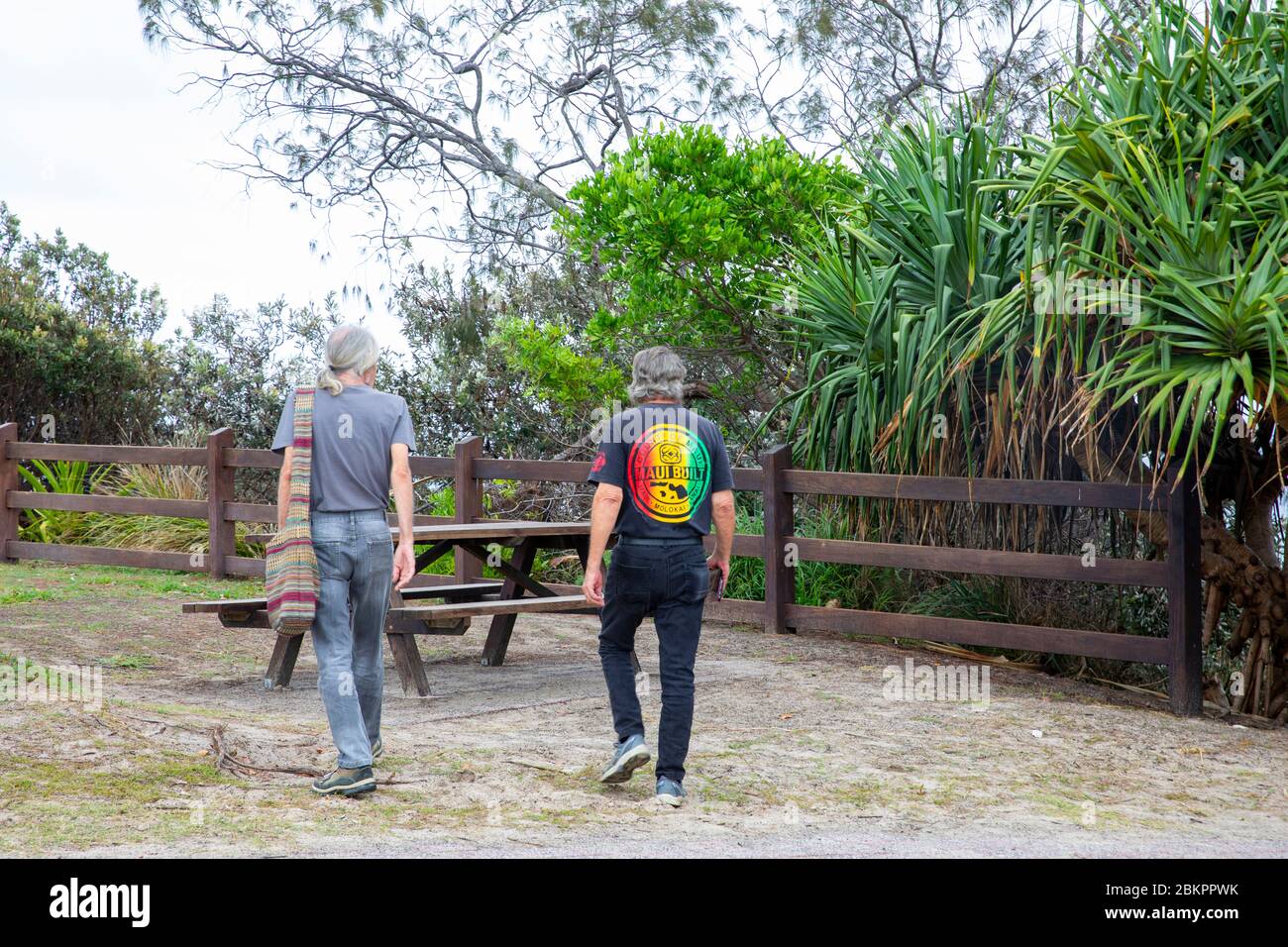 Zwei Männer mittleren Alters in Byron Bay genießen entspannte Kleidung und den Hippie-Vice-Lifestyle in Byron, Australien Stockfoto