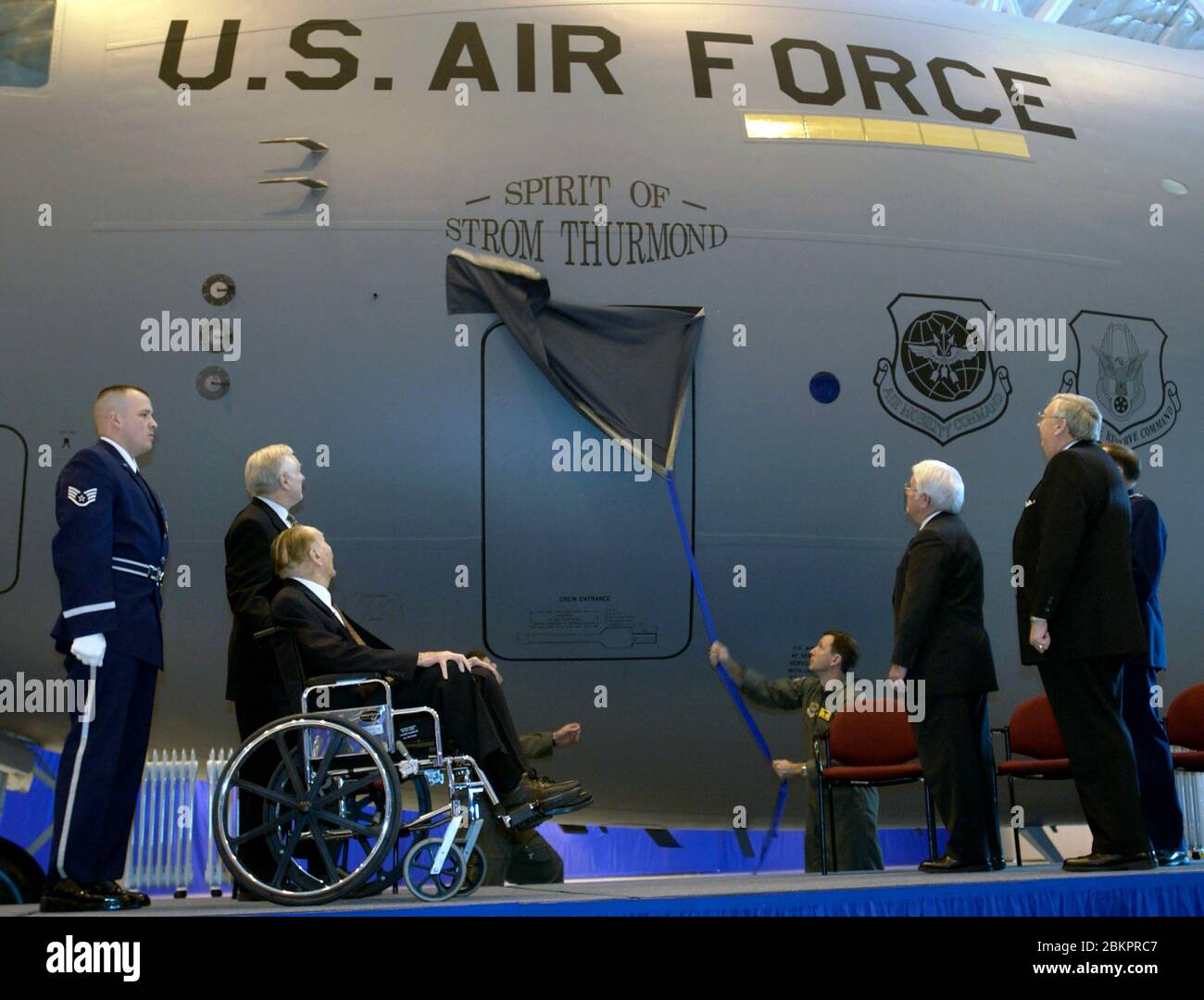 In diesem Foto von der United States Air Force veröffentlicht, US-Außenminister Dr. James G. Roche (rechts) sieht als "The Spirit of Strom Thurmond". Wird am 100. C-17 Globemaster III enthüllt, um die Montagelinie während einer Zeremonie zum 100. Geburtstag von US-Senator Strom Thurmond (Republikaner von South Carolina) zu Rollen, Im Rollstuhl sitzend, auf der Andrews Air Force Base, Maryland, 12. Dezember 2002. Thurmond, ein Veteran der Armee im Zweiten Weltkrieg, ist seit 48 Jahren US-Senator und Mitglied der Armed Services and Veterans' Affairs Committees des US-Senats. Das Feld „S. Stockfoto