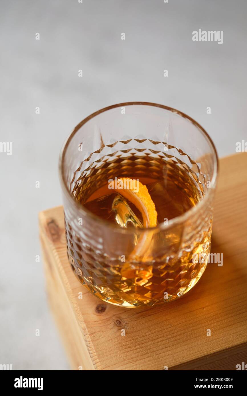 Alkoholisches Getränk im Glas mit Eiswürfeln auf einem Holztisch, Whiskey im Glas Stockfoto