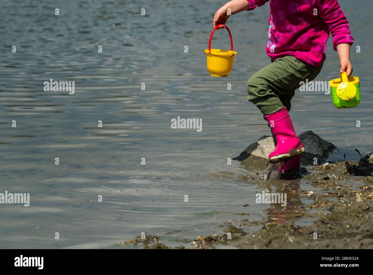 Ausgewogenes junges Mädchen Kind spielen auf dem natürlichen Flussufer. Macht sich mit der Natur in der Donau in Ungarn, Europa vertraut. Stockfoto