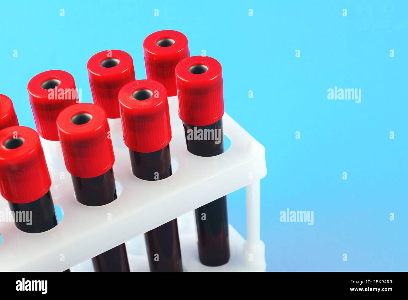 Blutentnahme-Vakuumröhrchen auf blauem Hintergrund mit Platz für Text Stockfoto