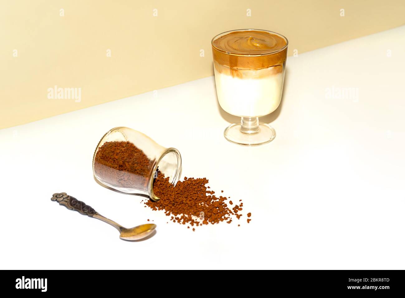 Eine Tasse eisgekühlter Dalgona Kaffee, modischer flauschiger cremiger Schlagkaffee auf einem trendigen farbigen Hintergrund. Stockfoto