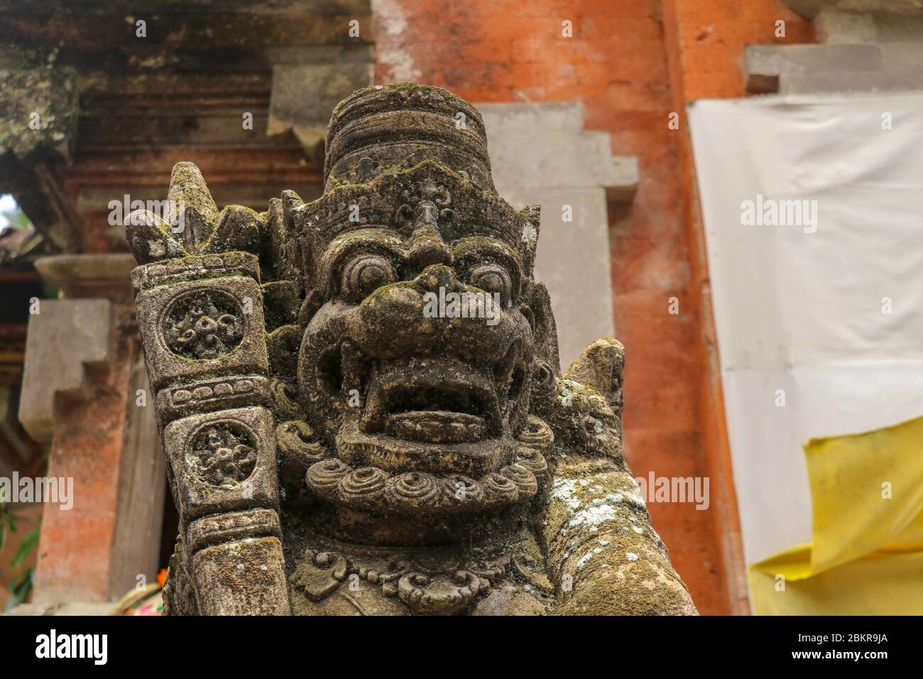 Eine Nahaufnahme einer Schutzfigur neben einem Hindu-Tempel auf Bali, Indonesien. Ein gemauert Eingangstor zu einem Hindu-Tempel auf Bali. Traditionell und historisch Stockfoto