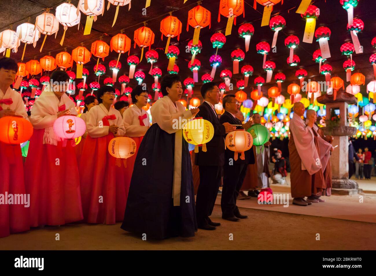 Südkorea, die Provinz Nord-Gyeongsang, der Jikjisa-Tempel, Frauen, die hanbok, traditionelle koreanische Kleidung tragen und im Laternen-beleuchteten Hof am Geburtstag Buddhas beten Stockfoto