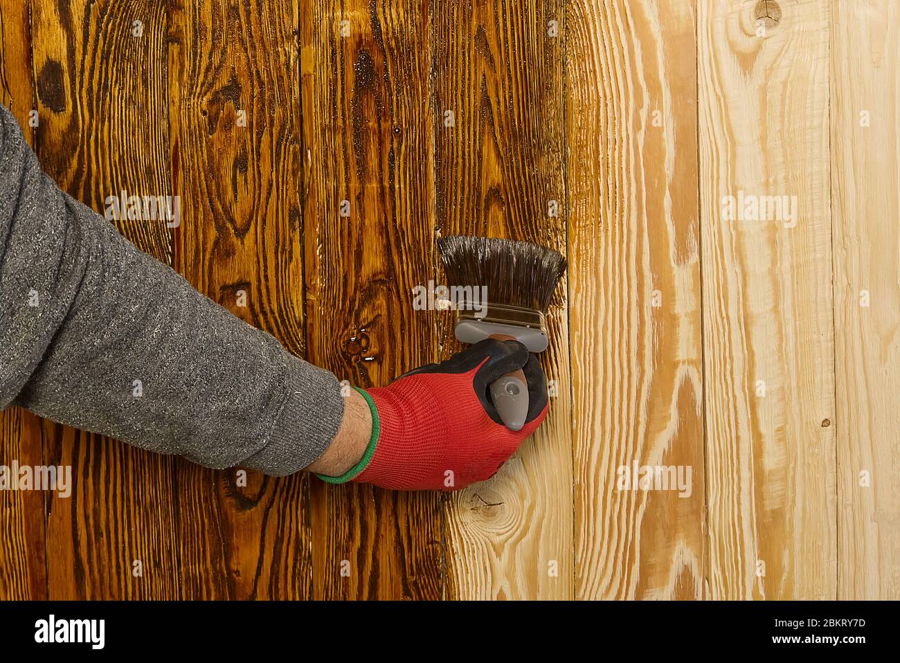 Erwachsene Zimmermann Malerei mit Wasser-basierte Farbe das Holz. Hausarbeit, mach es selbst. Imprägnierung mit gebürstetem Holz und natürlichem Öl Stockfoto