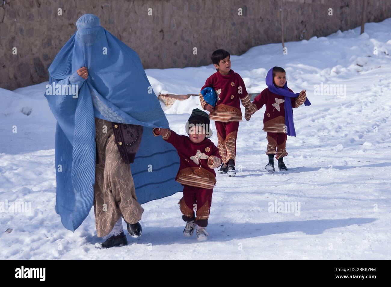 Estalef, Afghanistan - Januar 2005: Frauen nehmen Kinder mit auf einen Spaziergang im Winterschnee Stockfoto