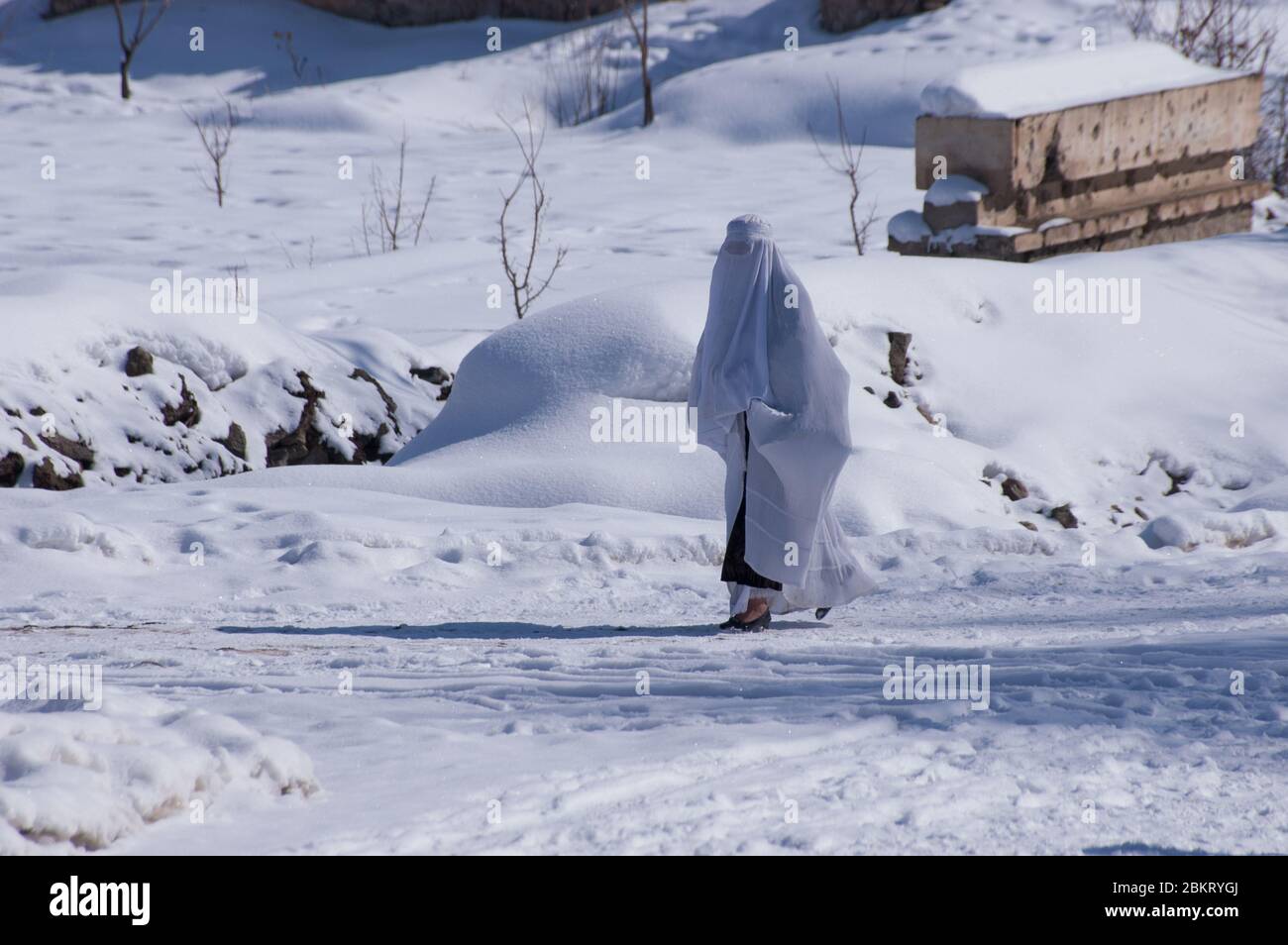 Estalef, Afghanistan - Januar 2005: Frau auf einen Spaziergang im Winterschnee Stockfoto