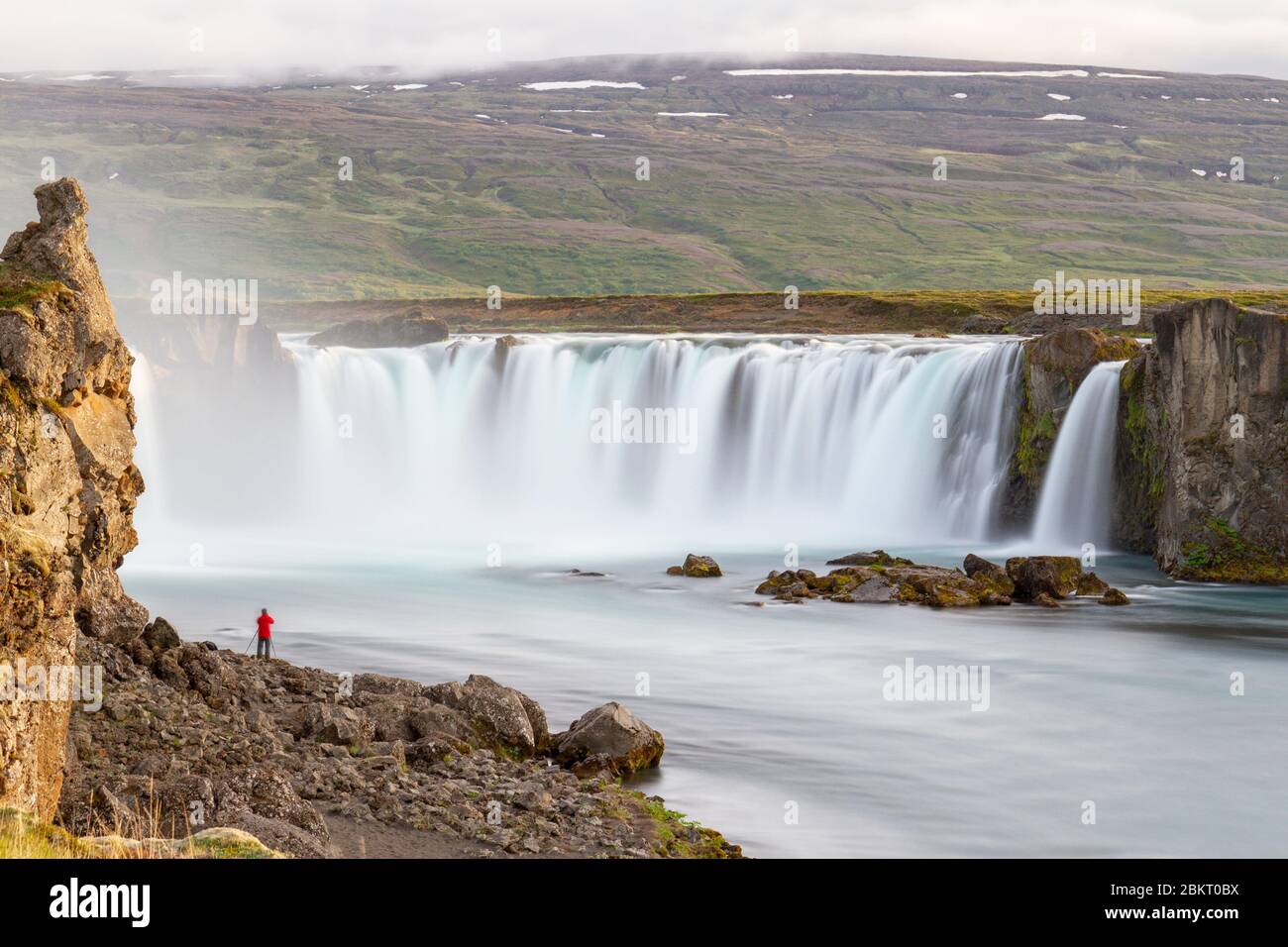 Langzeitbelichtung eines anderen Fotografen, der ein Foto des Goðafoss-Wasserfalls, eines 12 m hohen Sturzes über 30 m des Flusses Skjálfandafljót Island, machte. Stockfoto