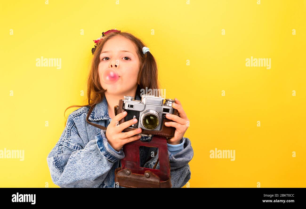 Kleines Mädchen mit Retro-Kamera auf gelbem Hintergrund. Das Kind zeigt  glückliche Emotionen und Posen. Tourismuskonzept. Kopierbereich  Stockfotografie - Alamy