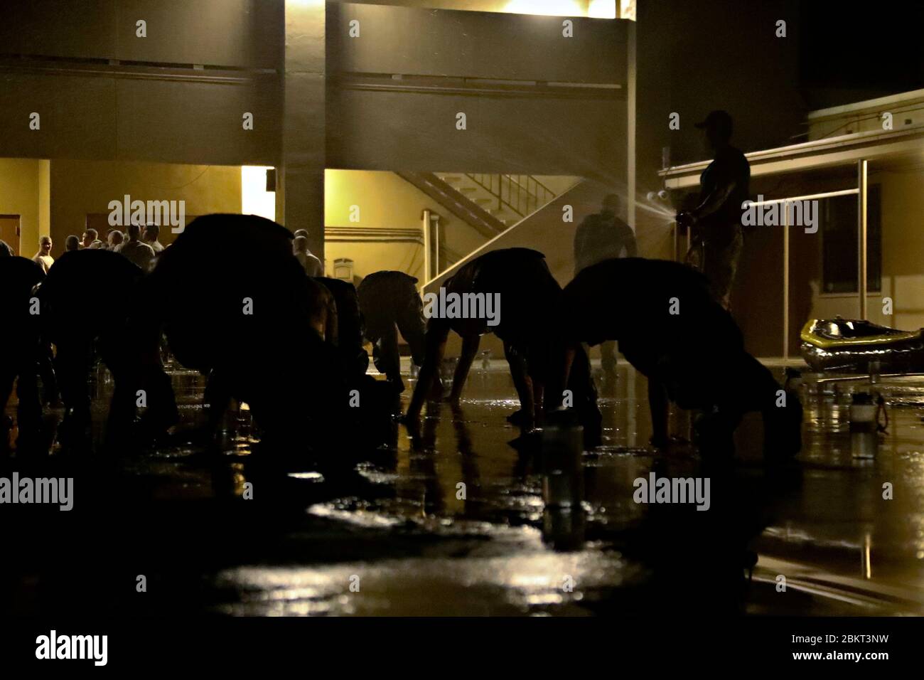 Die ROBBENKANDIDATEN der US-Marine führen Push-ups durch, während sie während der Mühle mit Wasser besprüht werden, Teil des Basic Underwater Demolition/SEAL Trainings im Naval Special Warfare Center 4. Mai 2020 in Coronado, Kalifornien. Die Selektions- und Beurteilungsschulung wurde aufgrund der COVID-19, Coronavirus-Pandemie, unterbrochen und wurde nun mit der Umsetzung der medizinischen Leitlinien wieder aufgenommen. Stockfoto