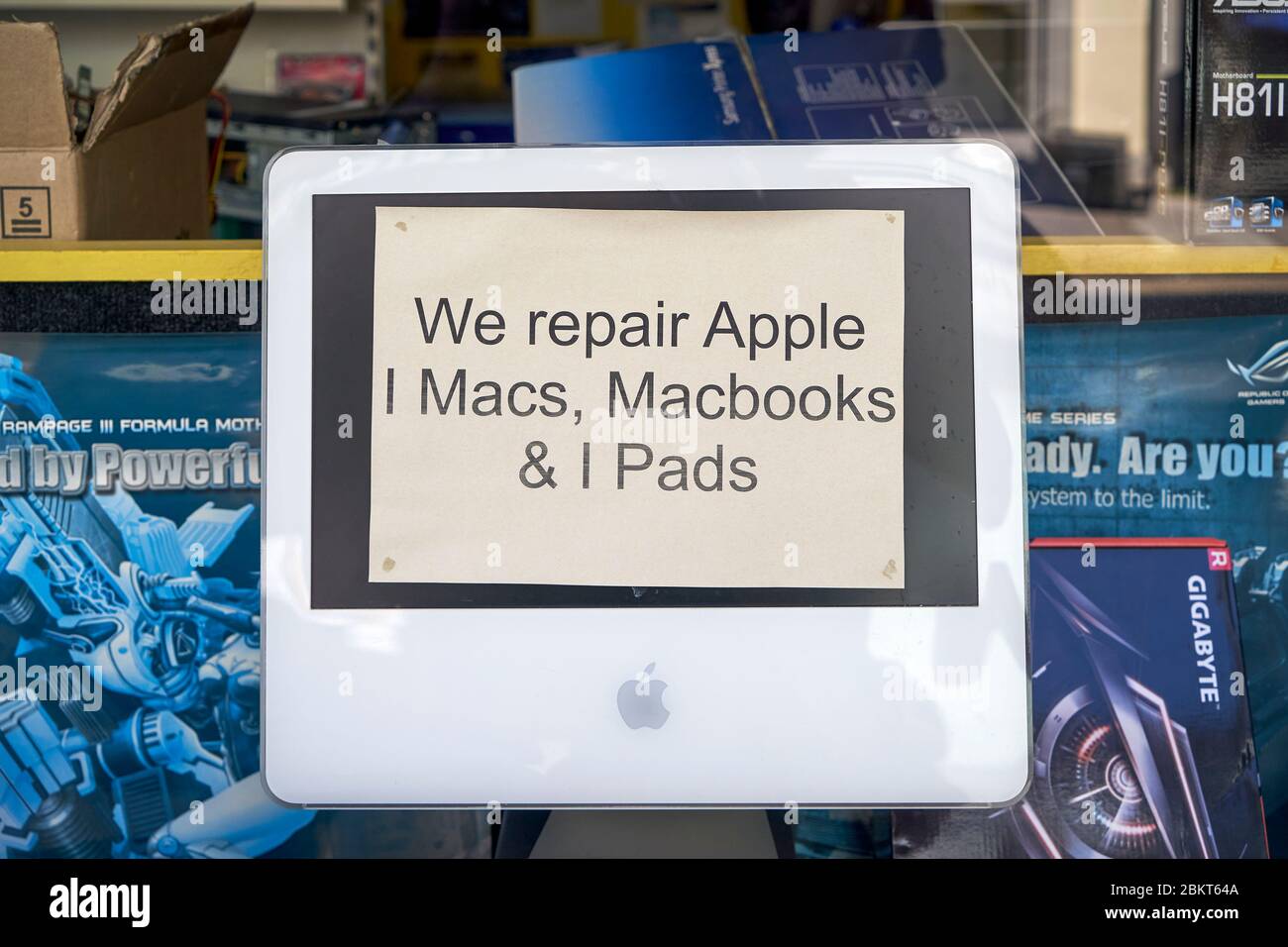 Alter iMac Computer im Schaufenster mit Hinweis Werbung für einen Reparaturservice für Apple-Geräte Stockfoto