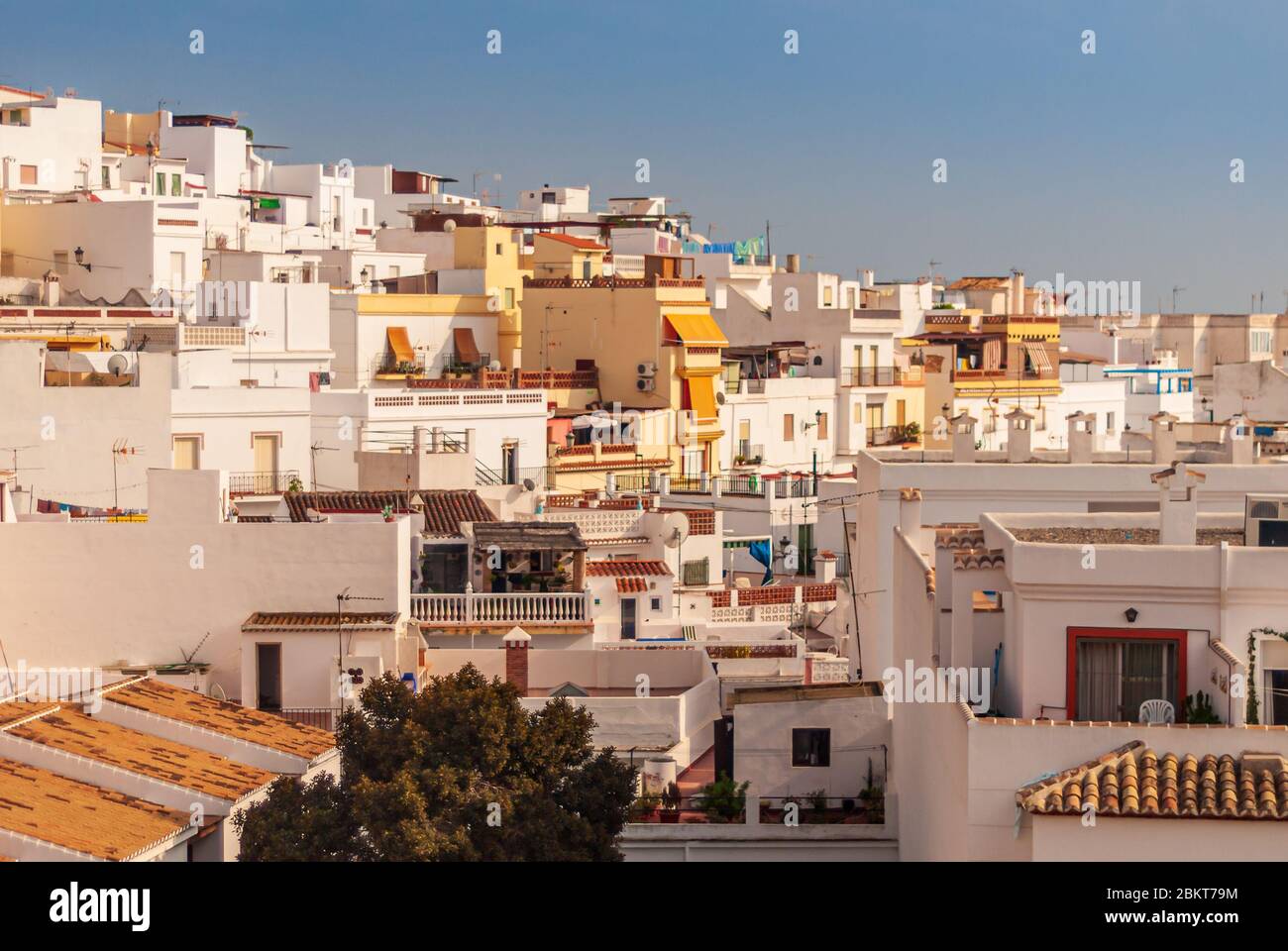 Blick über die Dächer von Häusern und Wohnungen im goldenen Sonnenlicht an der Costa Tropical Stadt La Herradura, Granada, Spanien Stockfoto