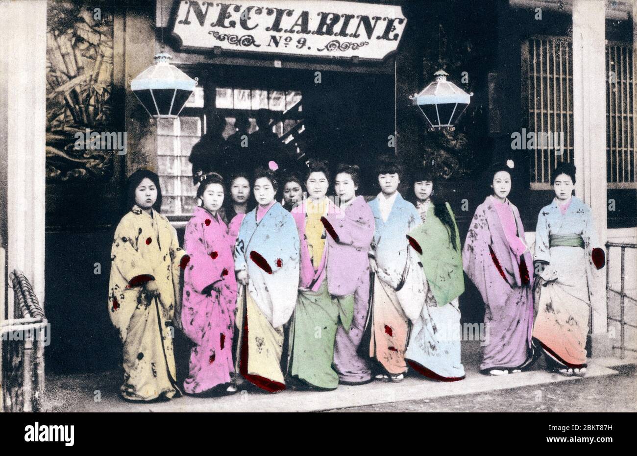 [ Japan 1900 - japanische Prostituierte ] - Prostituierte vor Japans berühmtestes Haus der Prostitution, bekannt als Jinpura (Nectarine) oder Nr. 9, in Yokohama, Präfektur Kanagawa, Ca. 1880er. Rudyard Kipling, der Japan 1889 besuchte (Meiji 22), erwähnte Jinpura in seinem Gedicht „McAndrew’s Hymn“ von 1894 (Meiji 27): „Blot die verwüsteten Stunden von mir in der Sünde aus, als ich verweilte. Jane Harrigan ist an’ Nummer neun, die Reddick an’ Grant Road“. Vintage-Postkarte des 20. Jahrhunderts. Stockfoto