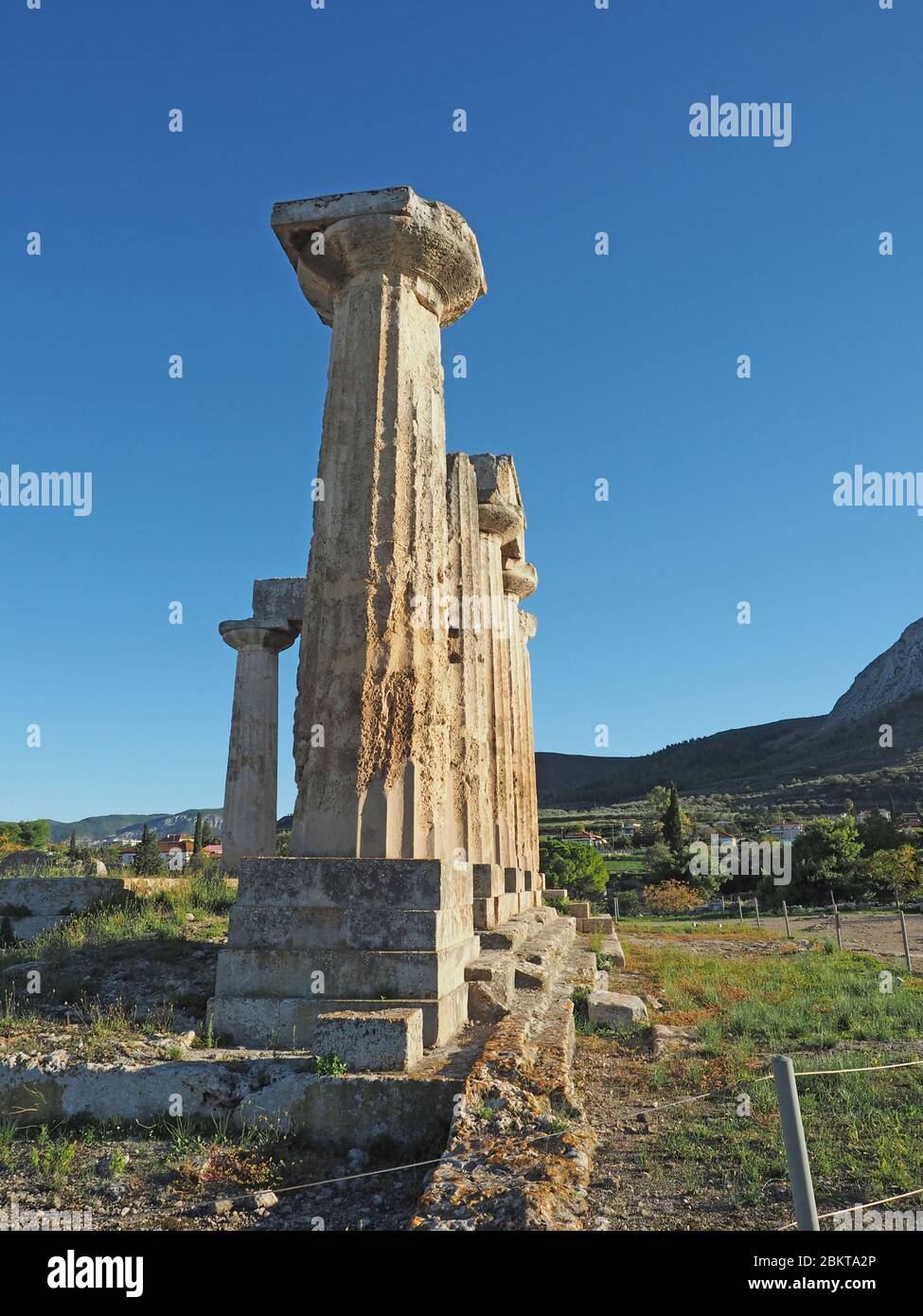 Dorische Säulen des Archaischen Tempels zu Apollo in Korinth, Peloponnes, Griechenland gegen einen blauen Himmel Stockfoto